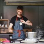 A chef carefully prepares crêpes in a cozy kitchen setting in Saint-Nazaire, France.